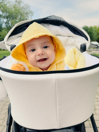Smiling Baby in Yellow Hoodie in Strollerの写真素材
