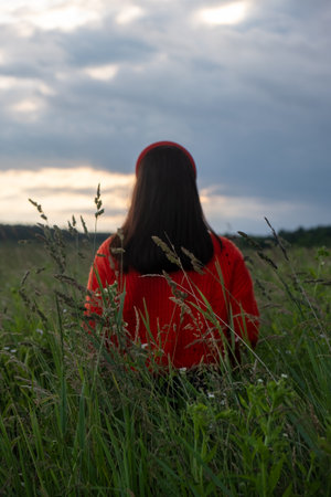 Woman in Red Sweater in Grassy Fieldの写真素材