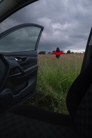 Person in Red Jacket Standing in Fieldの写真素材