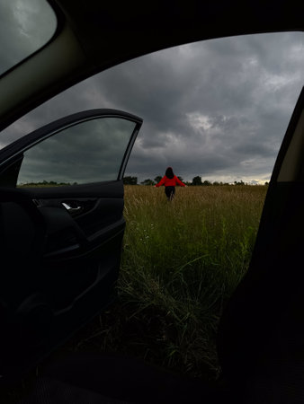 Person in Red Jacket Standing in Fieldの写真素材