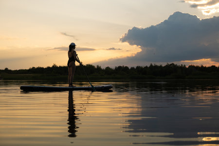 Paddleboarding at Sunset on a Tranquil Lake