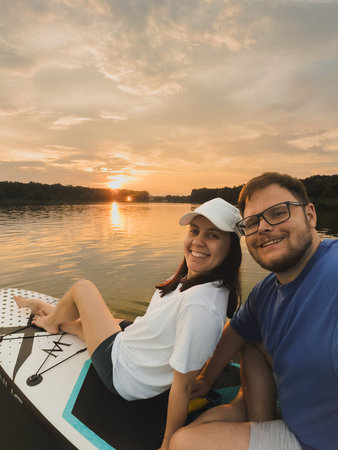 Couple Paddleboarding at Sunsetの写真素材