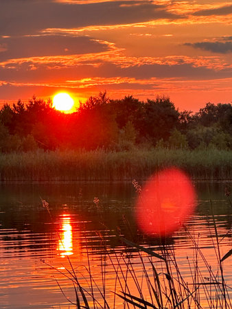Serene Sunset Reflection Over a Tranquil Lakeの写真素材