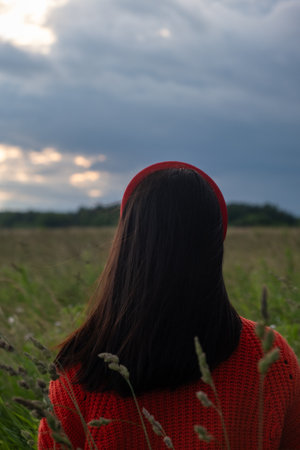 Woman in Red Sweater in Grassy Fieldの写真素材