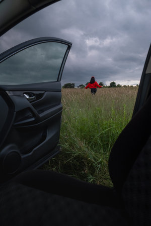 Person in Red Jacket Standing in Fieldの写真素材