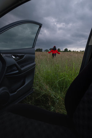 Person in Red Jacket Standing in Fieldの写真素材