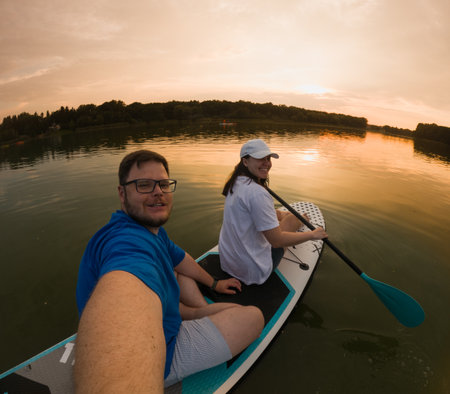 Couple Paddleboarding at Sunsetの写真素材