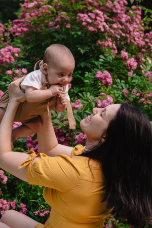 Joyful Mother and Baby in Blooming Gardenの写真素材