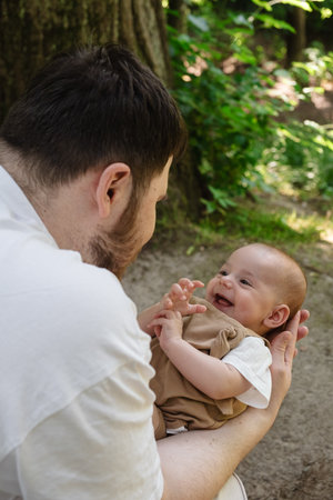 Father Holding Baby in Sunny Parkの写真素材