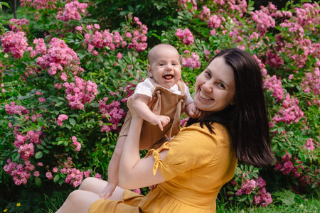 Joyful Mother and Baby in Blooming Gardenの写真素材