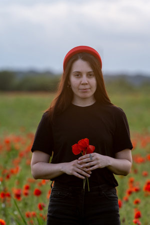 Young Woman in Poppy Field with Red Hatの写真素材