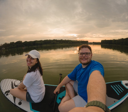 Couple Paddleboarding at Sunsetの写真素材