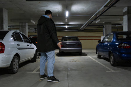 Person in Underground Parking Garage Figure Out of Stolen Carの写真素材