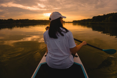 Paddleboarding at Sunset on a Calm Lakeの写真素材