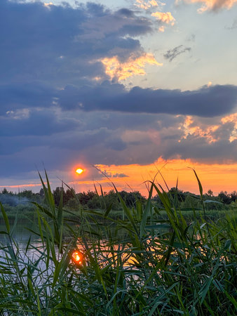 Serene Sunset Reflection Over a Tranquil Lakeの写真素材