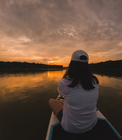 Paddleboarding at Sunset on a Calm Lakeの写真素材