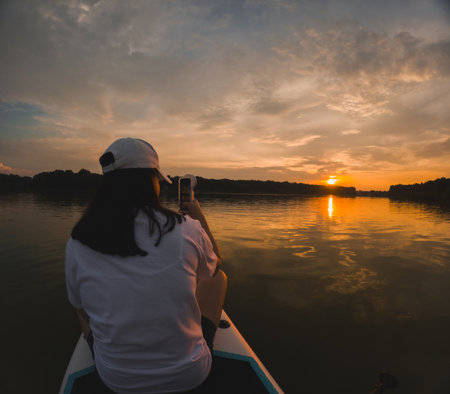 Paddleboarding at Sunset on a Calm Lakeの写真素材