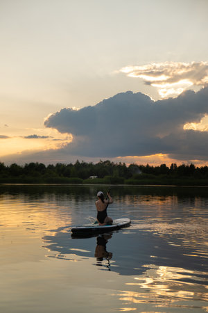Woman Relaxing on Paddleboard at Sunset