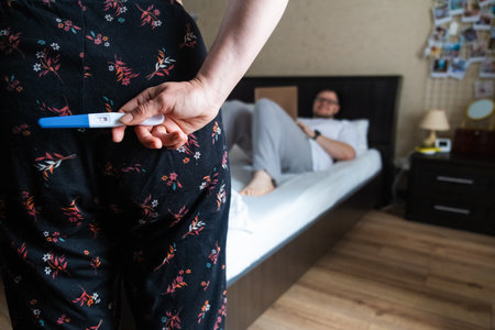 Positive Pregnancy Test Hidden Behind Backの写真素材