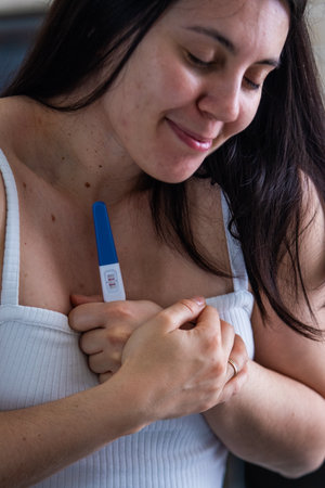 Surprised Woman with Positive Pregnancy Testの写真素材