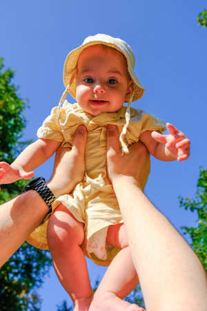 Joyful Baby Lifted in the Air Outdoors