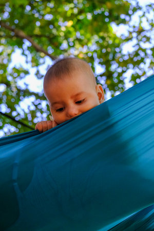 Baby Peeking Over Turquoise Fabric Outdoors