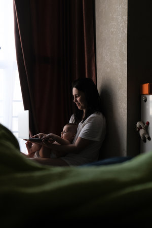 Mother and Baby Using Laptop by Windowの写真素材