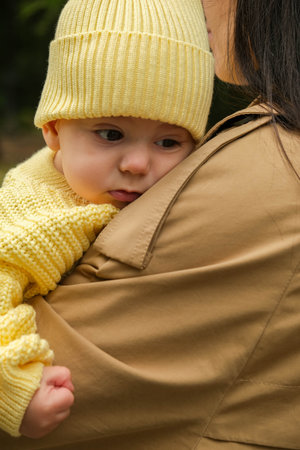 Mother Holding Baby in Yellow Outfit at Park