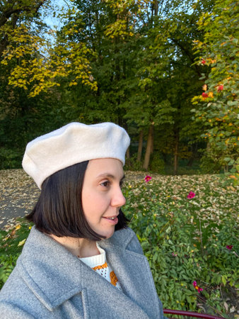 Woman in Gray Coat and Beret Smiling in Autumn Parkの写真素材