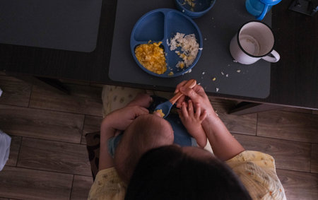 Baby Eating Rice and Eggs with Spoonの写真素材