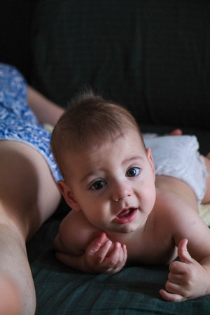 Playful Baby Lying on Bedの写真素材