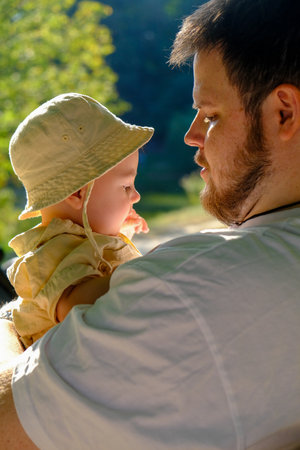 Father Holding Smiling Baby in Park