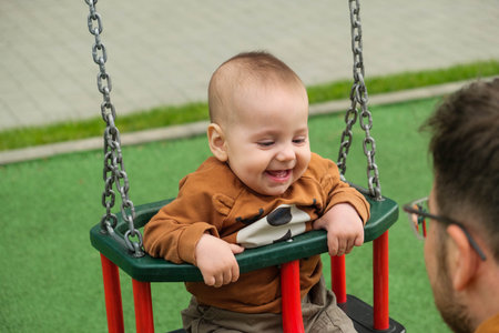 Happy Baby on Swing at Playgroundの写真素材