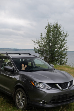 Feet visible in a parked car by the lake