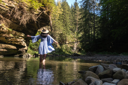 Woman Strolling by River in Forestの写真素材