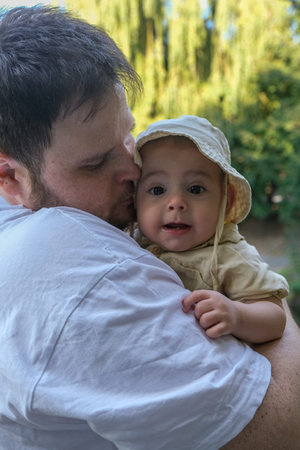 Father Holding Smiling Baby in Park