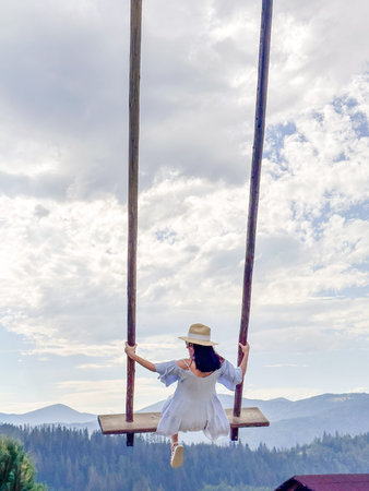 Woman Swinging Over Scenic Mountain Landscape