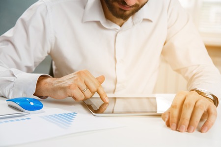 Business person analyzing financial statistics displayed on the tablet screen