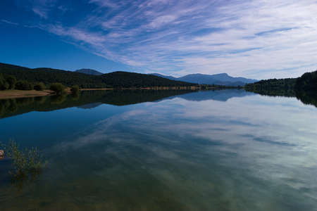 landscape lake view water embalse de la jarosa madrid trees mountains sky cloudsの写真素材