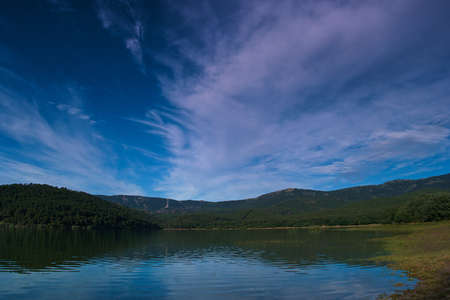landscape lake view water embalse de la jarosa madrid trees mountains sky cloudsの写真素材