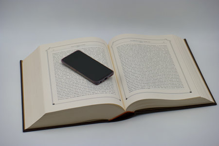 Smartphone lying on an open book. Smartphone on a book.の写真素材