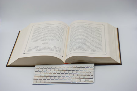Open book with keyboard and mouse on white background. education concept.の写真素材