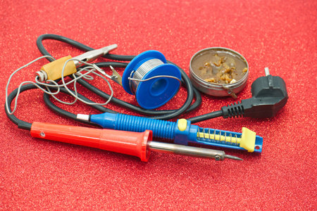 Electrician's tools and accessories for repairing electrical equipment on red background