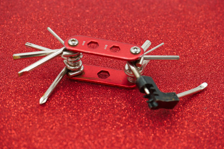 Close-up of a multi-tool on a red background.