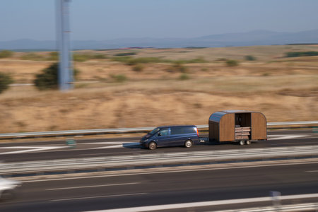 Car on the highway in Spain with a trailer in the foreground.の写真素材