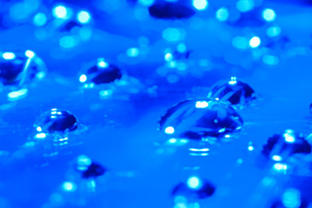 Blue water drops on a blue background close-up macro photography.