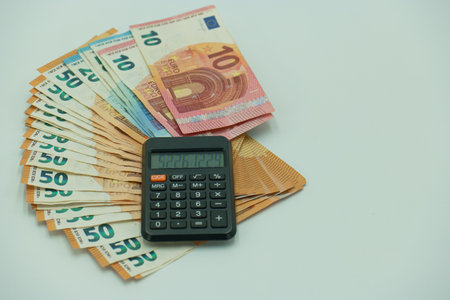 Calculator and Euro banknotes isolated on white background. Save money concept.の写真素材