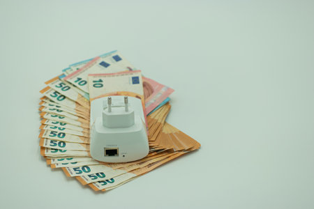Electrical power strip with euro banknotes on a white background.の写真素材
