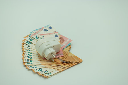 Electric plug and euro money on white background. Save money concept.