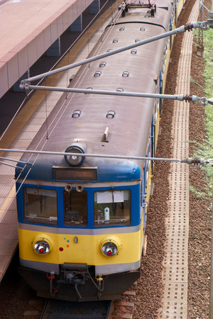 Railway station with a blue and yellow train on the platform.